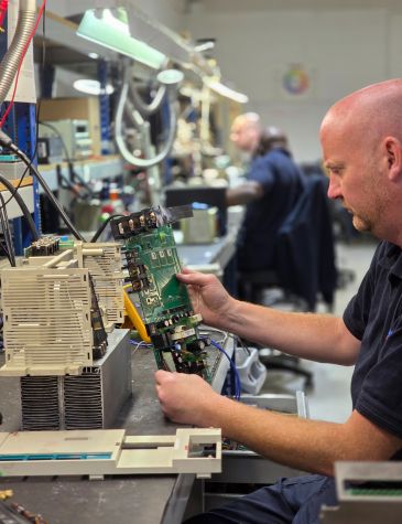 Engineer Dav working on CNC drive repairs at Neutronic Technologies workshop, testing and servicing an industrial drive unit on a workbench. Contact Neutronic for all type of CNC Repairs.