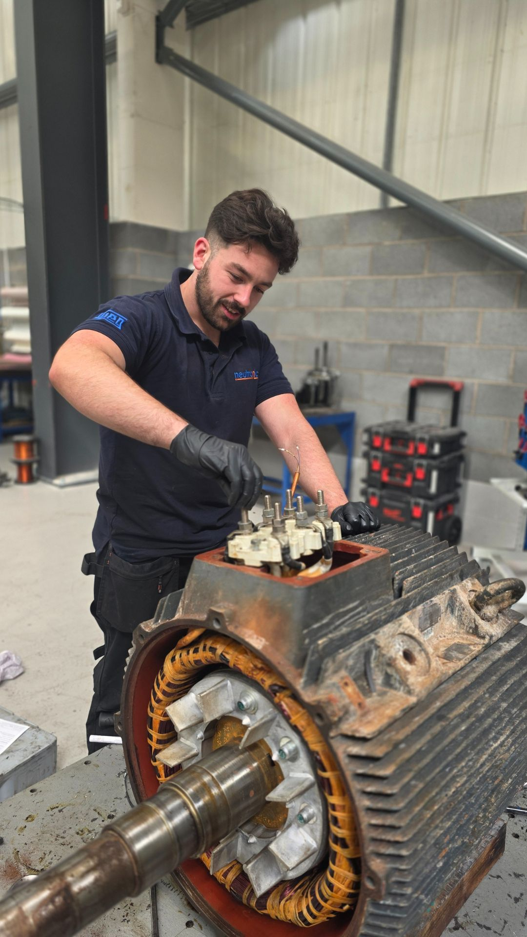 Neutronic Technologies engineer performing Industrial Rotating Equipment Repair on a large electric motor inside the company’s workshop, focusing on internal components and windings.