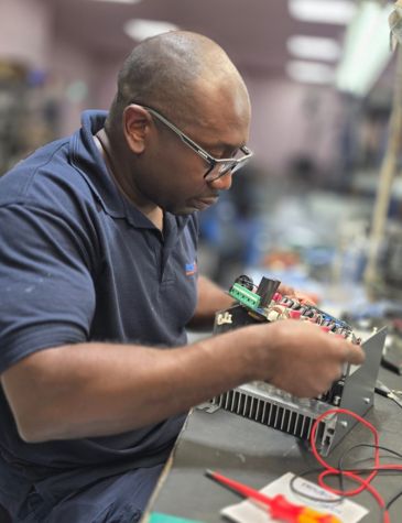 DC drive repair in progress at an electronics workshop, showing detailed work on internal circuit boards and wiring of an industrial DC drive unit.