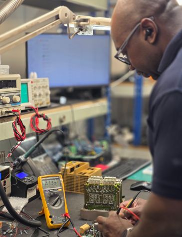 PLC repairs are carried out by a Neutronic Technologies engineer testing and diagnosing a PLC control board using specialist electronic equipment.